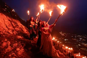 Iraqi Kurdish people carry fire torches, as they celebrate Nowruz