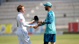 AP Photo/Anjum Naveed : England's Ollie Pope, left, shakes hand with Pakistan's Shan Masood on the end of the first test cricket match between Pakistan and England, in Multan.