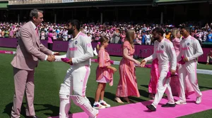 AP Photo/Mark Baker : Former Australian cricketer Glenn McGrath, left, takes pink caps from the Indian team ahead of play on the third day of the fifth cricket test between India and Australia at the Sydney Cricket Ground.