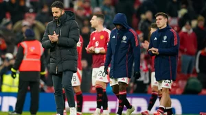 AP : Manchester United's head coach Ruben Amorim, left, walks on the pitch at the end of the English Premier League match against Brighton and Hove Albion at the Old Trafford stadium.