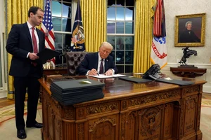 Associated Press : Trump signs an executive order in the Oval Office of the White House