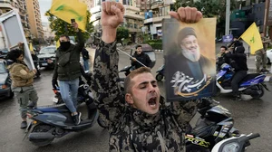 | Photo: AP/Bilal Hussein : Israel Lebanon Ceasefire: A man celebrates carrying a picture of slain Hezbollah leader Hassan Nasrallah