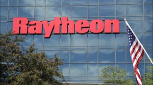 An American flag flies in front of the facade of Raytheon's Integrated Defense Systems facility.