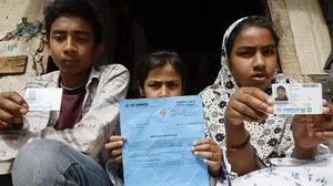 Hasina Begum's children showing their UNHCR documents.