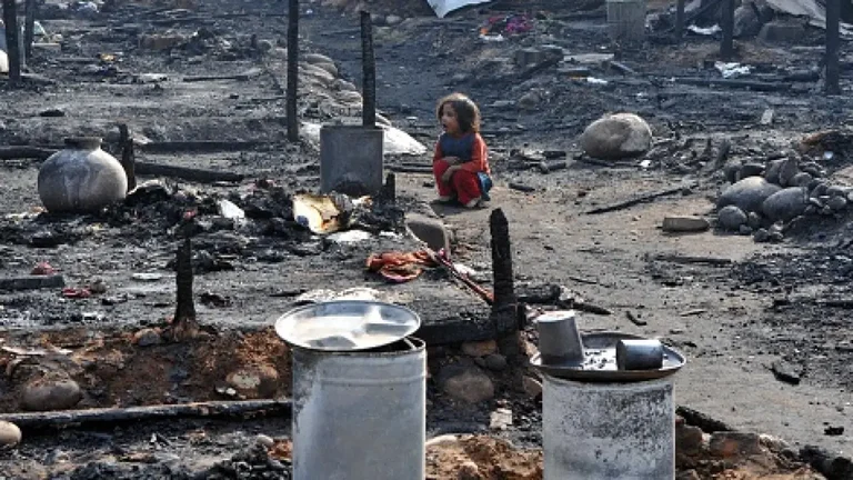 A Myanmar refugee lady looks for belongings after a fire at slum area outskirts of Jammu, on Novembe - null