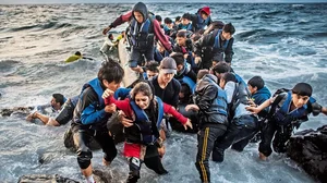 Scurrying to Safety: Refugees arrive on the shores of the Greek island of Lesbos in an inflatable boat from Turkey