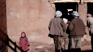 A young Hazara girl waits in the courtyard of an old mosque destroyed by the Taliban in 2018