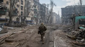 A Russian soldier walks amidst the rubble in Mariupols eastern side amid Russia-Ukraine war