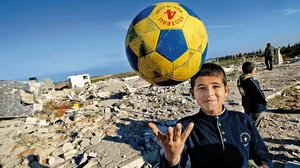 A Palestinian boy plays amidst the rubble of the destroyed Al-Aqsa university