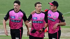 Sydney Sixers' Tom Curran (C) and Moises Henriques (R) in action at a Big Bash League match.