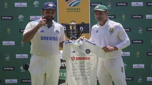 Rohit Sharma, left, presents Dean Elgar of South Africa, right, with a signed shirt from the Indian team as a retirement gift.