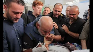 Wael Al-Dahdouh kissing the hands of his deceased son Hamza Al-Dahdouh