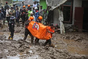 | Photo: AP/Binsar Bakkara : Indonesia Flash Floods: Rescuers carry the body of a victim in Karo