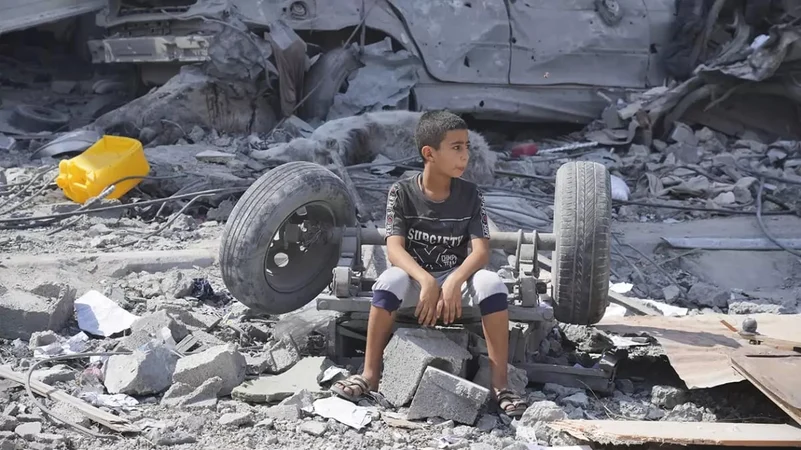 A child sits amid the rubble in Gaza.