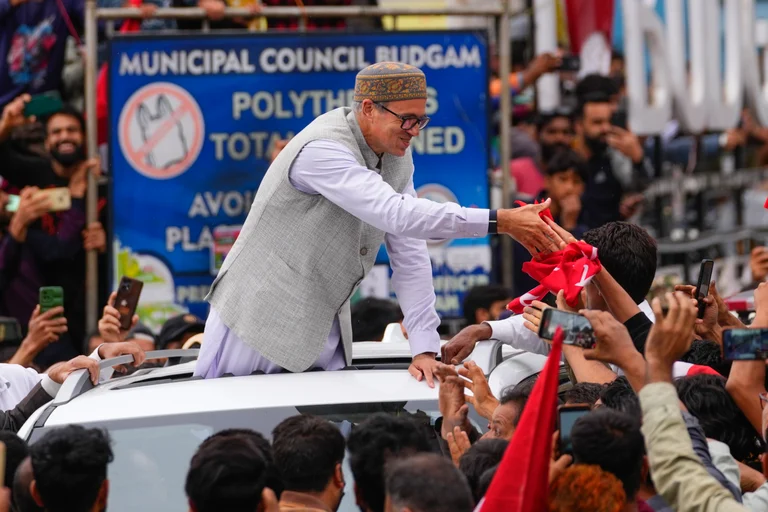 Jammu and Kashmir National Conference (JKNC) party leader Omar Abdullah, standing on car shakes hands with supporters as he celebrates his victory in the election in Budgam on Tuesday. - Dar Yasin via AP