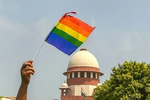 An activist waves a rainbow flag (LGBT pride flag) in front of the Supreme Court.