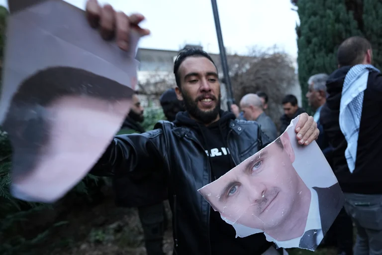 A man tears photo of Syrian President Bashar Assad in front of the Syrian embassy in Belgrade, Serbia, Sunday, Dec. 8, 2024.  - AP Photo/Darko Vojinovic