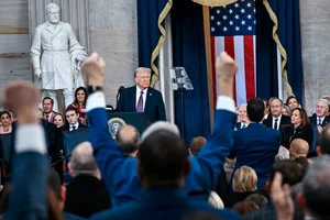 Kenny Holston/The New York Times via AP, Pool        : Attendees cheer as President Donald Trump speaks after taking the oath of office during the 60th Presidential Inauguration in the Rotunda of the U.S. Capitol in Washington, Monday, Jan. 20, 2025. 