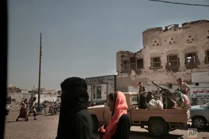 AP/Nariman El-Mofty : Women walk past Saudi-led coalition backed forces, leading the campaign to take over Hodeida, as they patrol Mocha, a port city on the Red Sea coast of Yemen |