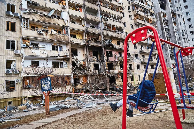 A child outside a residential building damaged by a missile strike in Kyiv, Ukraine