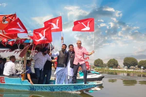 PTI : National Conference Vice President Omar Abdullah holds the party flag as he takes a 'shikara' ride during a rally for Jammu & Kashmir Assembly elections