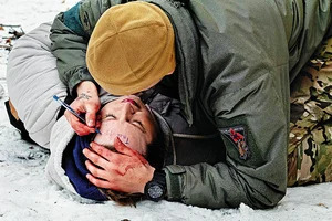 Photo: Carlo Cozzoli/Memora : From Ground Zero: A soldier puts a timestamp on the forehead of a woman who was seriously injured in the sudden Russian shelling in Kramatorsk. The timestamp signifies the time he applied the first aid before she could be rushed to the hospital for further treatment