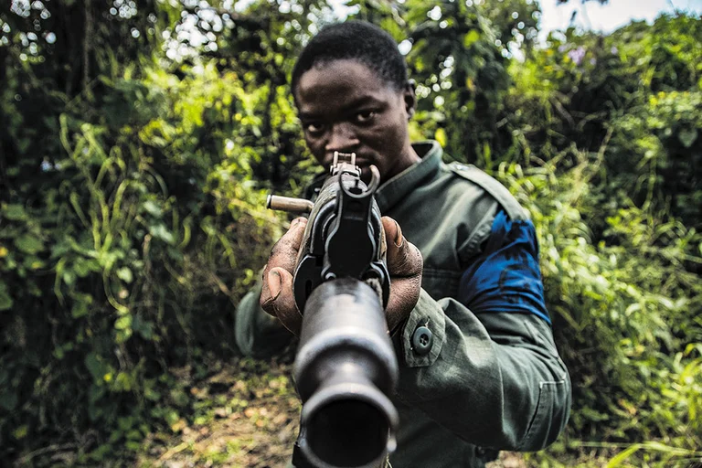 On Guard: A young resistance fighter with his rifle in firing position at the headquarters of the Wazalendo resistance movement in Kanyambongo, Nyiragongo territory, North Kivu province in East Democratic Republic of Congo - | Photos: Daniel Buuma