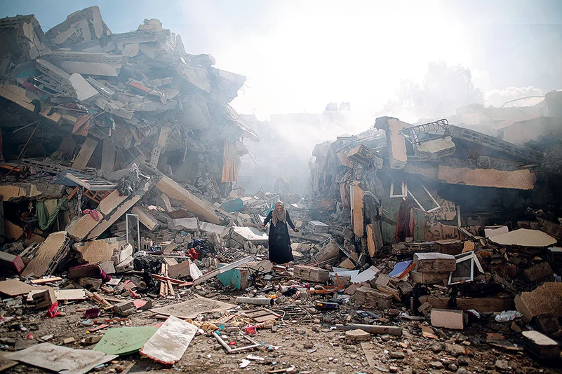 A resident walks through the rubble of residential buildings after Israeli air-strikes in Gaza Strip