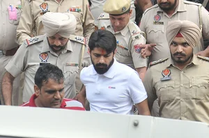 Getty Images : Gangster Lawrence Bishnoi amid heavy police security while coming out of the Amritsar court complex on October 31, 2022 in Amritsar, India. 