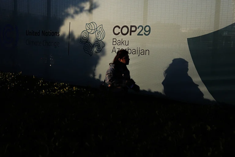 Young girl walks along a fence near the Baku Olympic Stadium - Getty Images