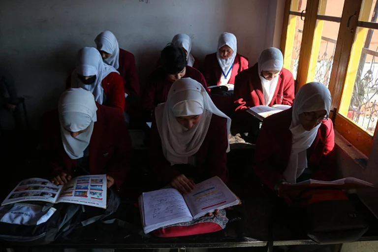 Students read books in a classroom during the first day of classes after the resumption of school activities that were interrupted by the severe winter. Students across the valley head to their schools following a two-month-long winter break.  - Firdous Nazir/ Eyepix Group/Future Publishing via Getty Image