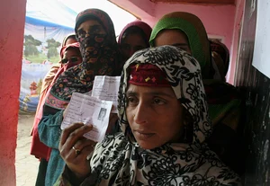 (Photo by Yawar Nazir/Getty Images) : Kashmiri women wait in queue to cast their votes outside a polling station during the second phase of assembly elections on December 02, 2014, in Kulgam.