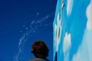 AP : A man looks at the Israeli Iron Dome air defense system as it fires to intercept rockets that were launched from Lebanon, in Safed, northern Israel, Sunday, Sept. 29, 2024. 