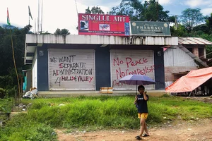 Photo: Sandipan Chatterjee : Future Tense?: A child walks past graffiti in Kangpokpi, Manipur