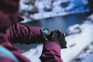 lzf/Shutterstock : A hiker checks her sports watch in the mountains