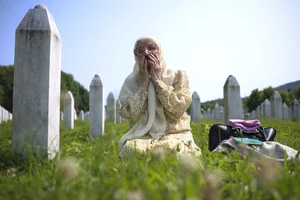 AP : A Bosnian muslim woman mourns next grave of her relative, victim of the Srebrenica genocide, in Memorial Centre in Potocarı, Bosnia, Tuesday, July 11, 2023 |