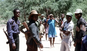 ZANLA GUERRILLAS : RHODESIA 1980, Armed members of the ZANLA patriotic front and their womenfolk at a ceasefire assemby point called Foxtrot, 130 miles SW of Salisbury (now Harare), where they are waiting in a camp run by British troops before the Rhodesian General Election